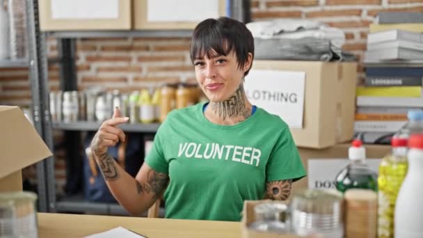 Mujer Hispana Con Brazo Amputado Sentada Mesa Señalando Uniforme Voluntario — Vídeos de Stock