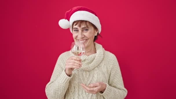 Starší Hispánská Žena Usměvavá Sebevědomý Nošení Vánoční Klobouk Pití Sklenice — Stock video