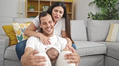 Üç kişilik aile evdeki kanepede oturuyor.
