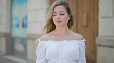 Genç sarışın kadın gülümsüyor. Elinde İtalyan bayrağı tutuyor.