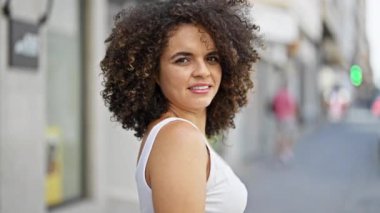 Genç, güzel, İspanyol bir kadın gülümsüyor. Kendine güveniyor.