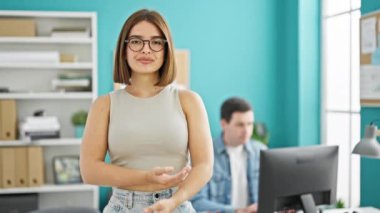 İki işçi adam ve kadın, ofiste çalışırken kollarını kavuşturdular.