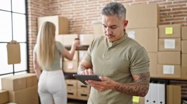 Erkek ve kadın ecommerce işçileri ofiste dokunmatik ped kontrol paketleri kullanarak