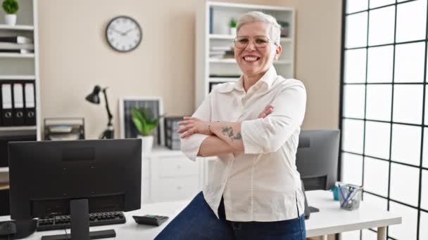 中年白发苍苍的女实业家微笑着 自信地坐着 双手交叉地在办公室里摆出姿势 — 图库视频影像