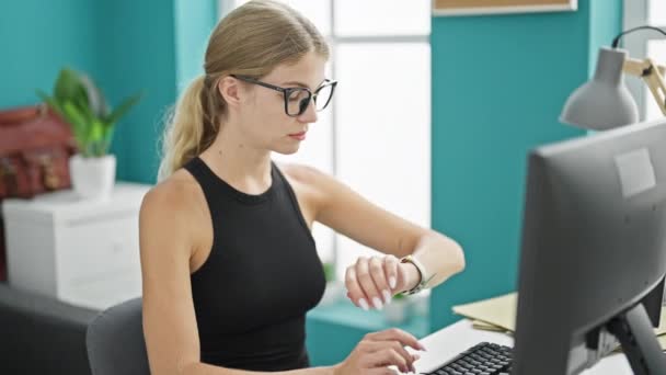 Joven Mujer Rubia Trabajadora Negocios Usando Computadora Mirando Reloj Cansado — Vídeo de stock