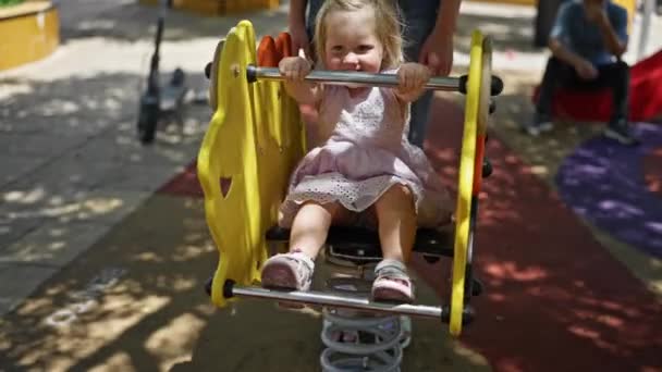 遊び場公園でスイングで幸せに座って遊んでいる白人赤ん坊の少女 — ストック動画