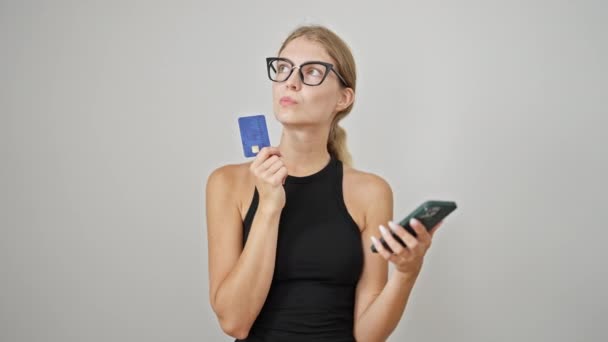 Jovem Loira Comprando Com Smartphone Cartão Crédito Pensando Sobre Fundo — Vídeo de Stock