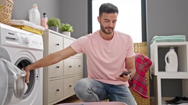 Genç Spanyol Adam Çamaşır Odasında Çamaşır Yıkamak Için Akıllı Telefon — Stok video