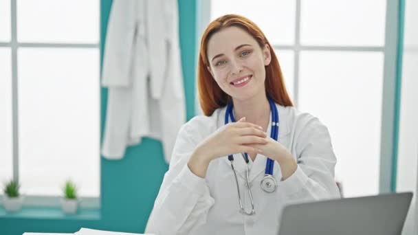 Молода Руда Жінка Лікар Посміхається Робити Жест Серця Руками Клініці — стокове відео