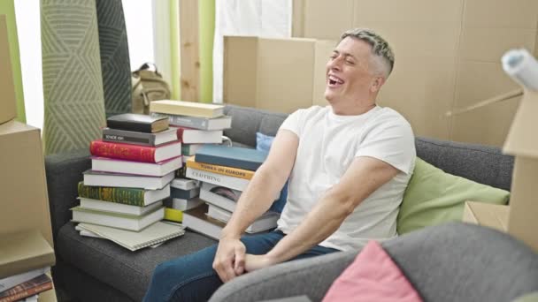 Joven Caucásico Hombre Sonriendo Confiado Sentado Sofá Relajante Nuevo Hogar — Vídeos de Stock