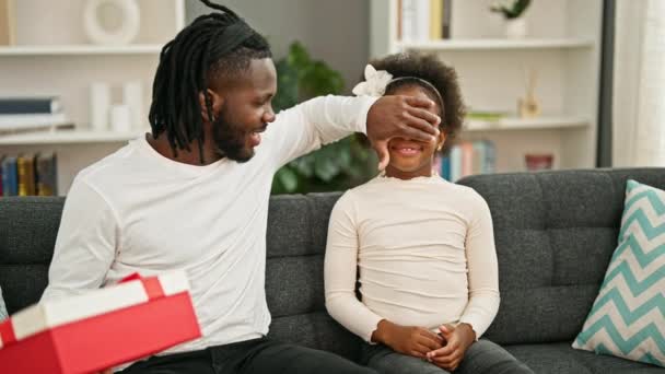 Afro Americanos Padre Hija Sorpresa Con Regalo Sentado Sofá Sonriendo — Vídeo de stock