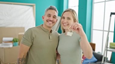 Erkek ve kadın çift yeni evlerinde birbirlerine sarılıyorlar.