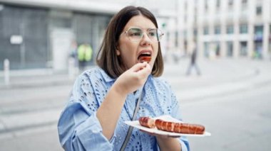 Genç ve güzel İspanyol kadın Viyana sokaklarında Ksekrainer sosisi yiyor. 