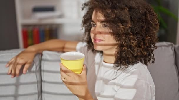 Genç Güzel Spanyol Kadın Evdeki Kanepede Oturup Kahve Içiyor — Stok video