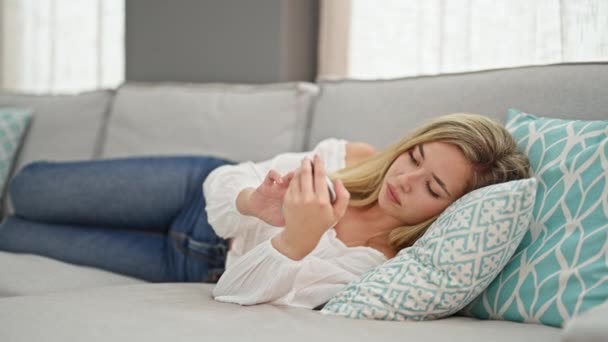 Mujer Rubia Joven Usando Teléfono Inteligente Tumbado Sofá Cansado Dormir — Vídeo de stock