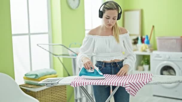 Ung Blond Kvinna Lyssnar Musik Strykning Kläder Tvättstuga — Stockvideo