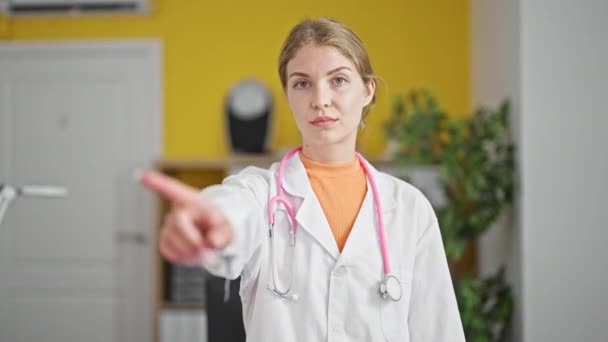 年轻的金发女医生严肃地站在那里 在诊所用手指说不 — 图库视频影像