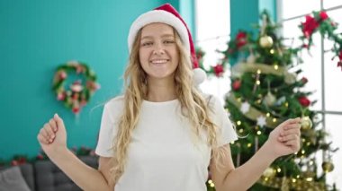 Genç sarışın kadın Noel 'i kutluyor evde dans ediyor