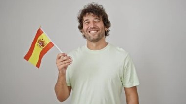 İspanyol genç adam gülümsüyor. İspanyol bayrağını izole edilmiş beyaz arka planda tutuyor.