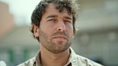 Sokakta ciddi bir ifadeyle duran İspanyol genç adam.