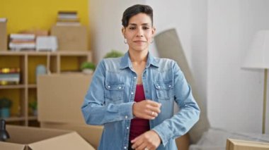 Young beautiful hispanic woman smiling confident standing with arms crossed gesture at new home
