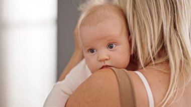 Mother and daughter hugging each other standing at home