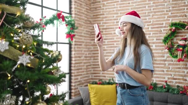 自宅でスマートフォンでクリスマスツリーに写真を撮る若い美しいヒスパニックの女性 — ストック動画