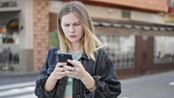 Mujer Rubia Joven Usando Teléfono Inteligente Con Cara Seria Terraza — Vídeos de Stock