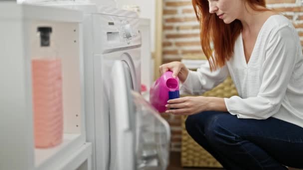 Młoda Ruda Kobieta Myje Ubrania Nalewając Detergent Pralni — Wideo stockowe