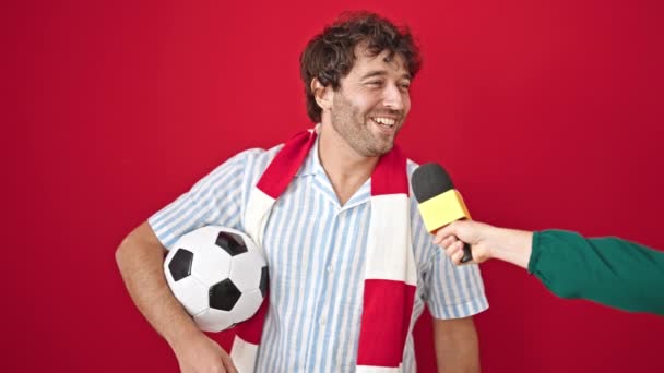 Ung Latinamerikan Man Stödja Fotbollslag Har Intervju Över Isolerad Röd — Stockvideo