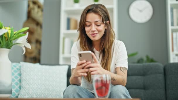 Mujer Hispana Hermosa Joven Usando Teléfono Inteligente Sentado Sofá Sonriendo — Vídeos de Stock