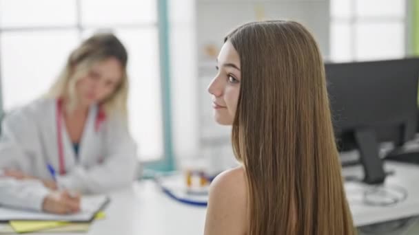 若い美しい女医と患者が診療所で親指でジェスチャーをしている医療相談を受ける — ストック動画