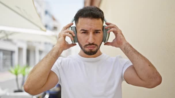 Junger Araber Nimmt Kopfhörer Mit Ernstem Gesicht Auf Der Straße — Stockvideo