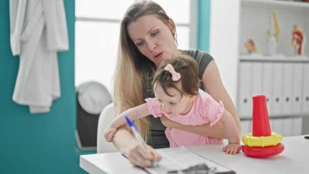 Madre Hija Firmando Documento Clínica — Vídeo de stock
