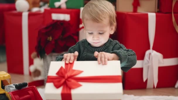 Αξιολάτρευτο Ξανθό Νήπιο Ξεπακετάρει Χριστουγεννιάτικο Δώρο Κάθεται Στο Πάτωμα Στο — Αρχείο Βίντεο