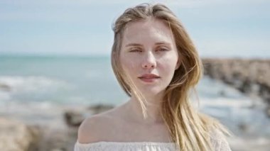 Kumsalda kendine güvenen genç sarışın bir turist.