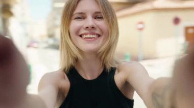 Genç sarışın kadın gülümsüyor. Kendine güveni tam.