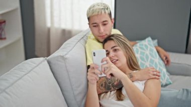Güzel bir çift evde akıllı telefon kullanıyor.