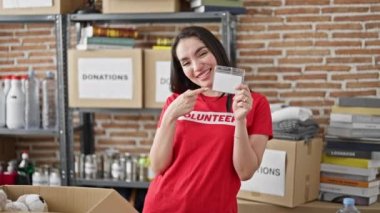 Genç ve güzel İspanyol kadın gönüllü yardım merkezindeki kimlik ve kameraya işaret ediyor.