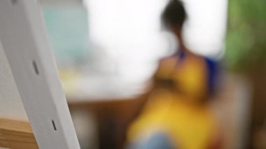 Resim stüdyosunda gülümseyen Afrikalı Amerikalı kadın sanatçı.