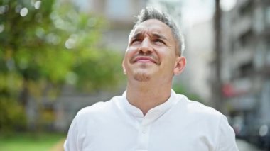 Genç İspanyol adam kendine güvenen gülümsüyor. Kazanan jestlerle gökyüzüne bakıyor.