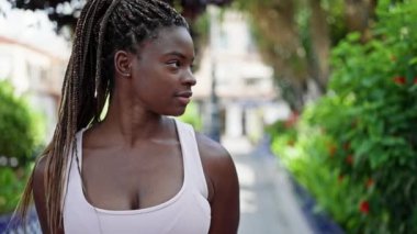 African american woman standing with serious expression at park