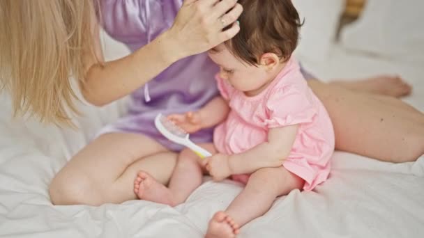 Mãe Filha Sentadas Cama Colocando Fita Cabelo Bebê Quarto — Vídeo de Stock