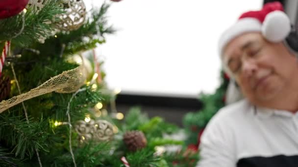 自宅でクリスマスツリーでソファーで眠っている灰色の髪を持つ中年男性 — ストック動画