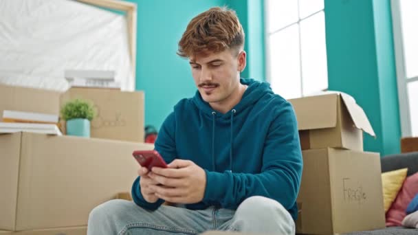 Ung Latinamerikan Man Med Smartphone Sitter Soffan Nytt Hem — Stockvideo
