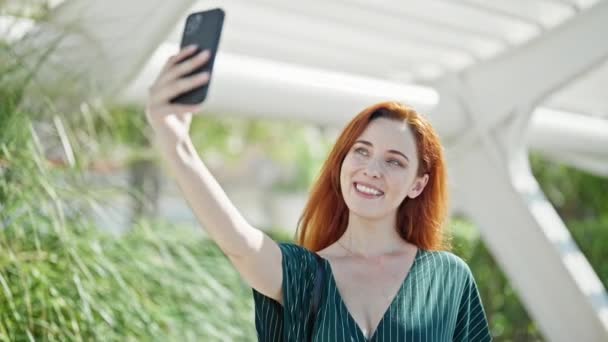 Jovem Ruiva Sorrindo Confiante Fazendo Selfie Pelo Smartphone Parque — Vídeo de Stock