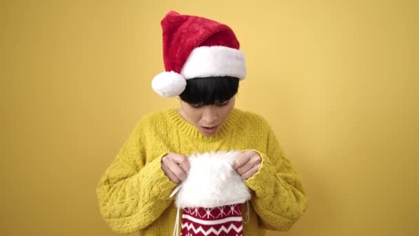 Молодая Китаянка Улыбается Уверенно Держа Рождественский Носок Изолированном Желтом Фоне — стоковое видео