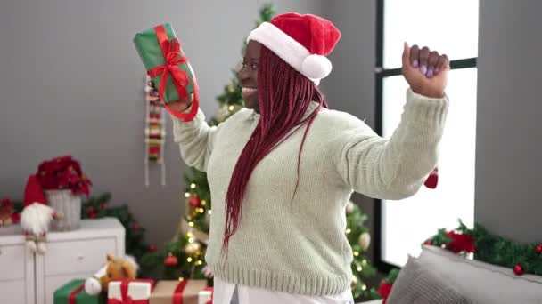 Afrikanerin Mit Geflochtenem Haar Tanzt Weihnachtsbaum Und Hält Geschenk Hause — Stockvideo