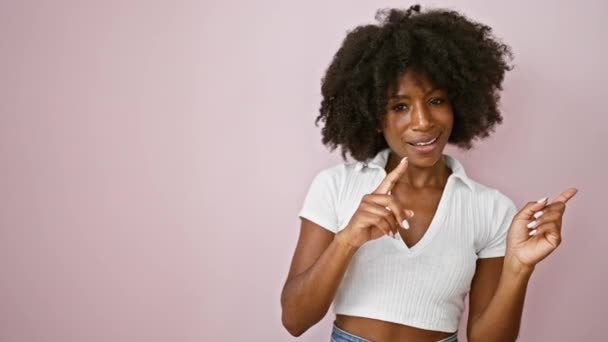 African American Woman Smiling Pointing Side Isolated Pink Background — Stock Video