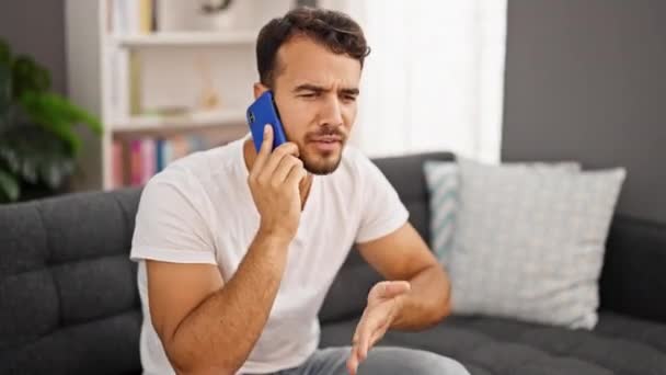Young Hispanic Man Speaking Phone Sitting Sofa Arguing Home — Stock Video